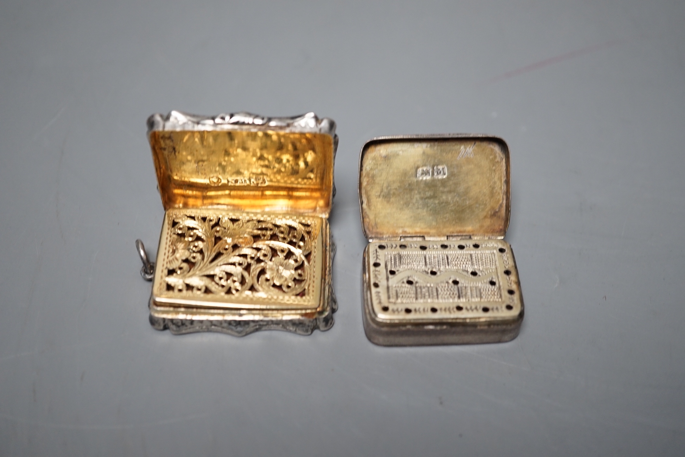 A Victorian engraved silver shaped rectangular vinaigrette, by Nathaniel Mills, Birmingham, 1845, 36mm and a George III silver vinaigrette, London, 1807, 31mm.